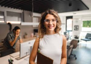 Female marketing manager in an office with a male colleague in the background