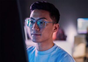 An embedded computing student is entering code on a large monitor