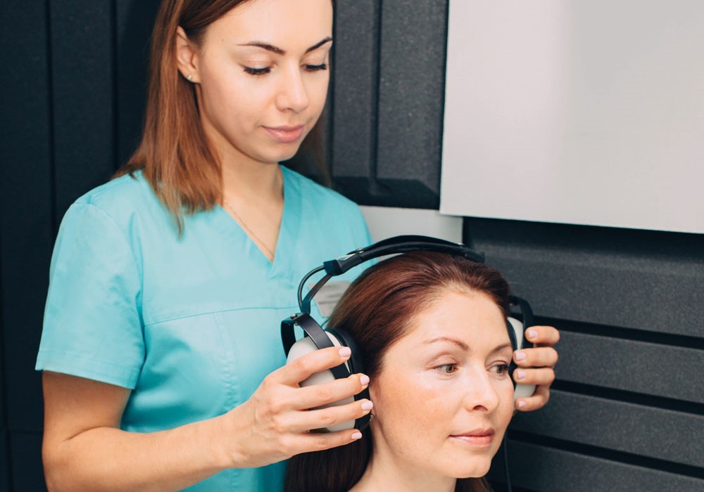 Hearing Care Assistant helps a customer with a hearing device