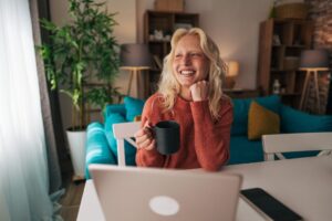Young woman working remotely from home reflecting on her work