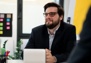 Policing professional attentively listens during a formal meeting, showcasing teamwork and attention to detail in a professional workspace.