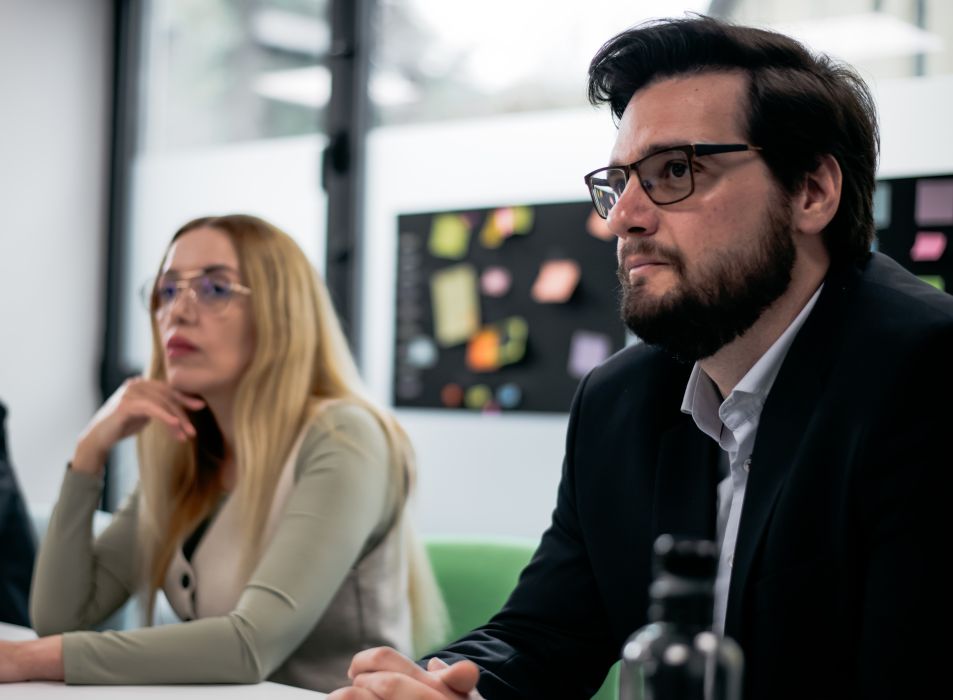Policing professionals attentively listen during a formal meeting, showcasing teamwork and attention to detail in a professional workspace.