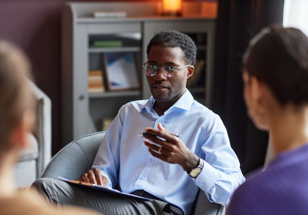 Portrait of family psychologist talking to couple at a therapy session