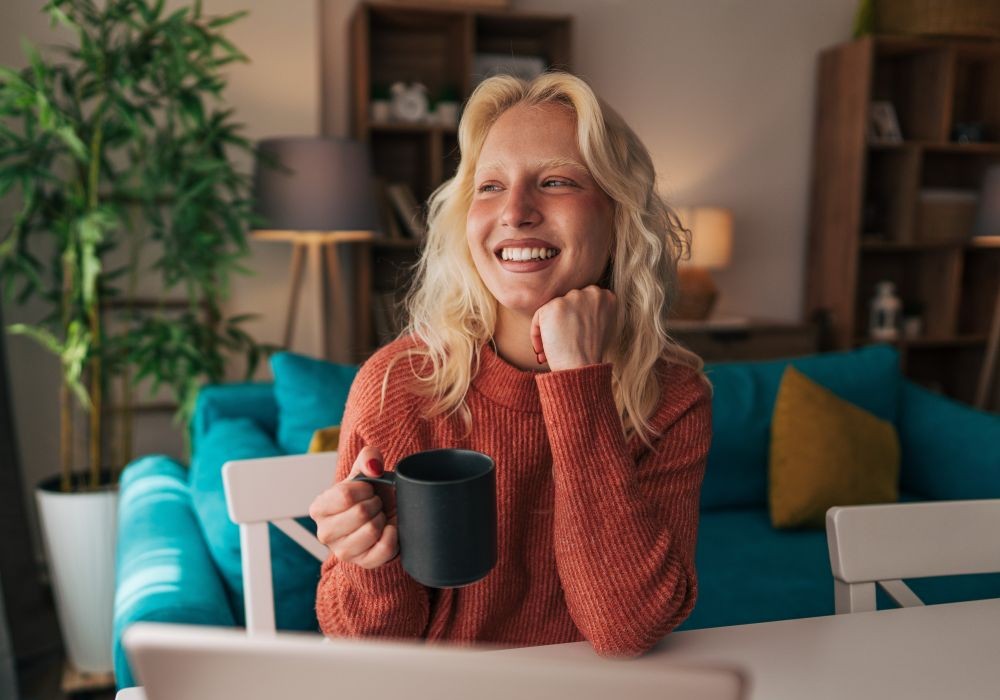 Young woman working remotely from home reflecting on her work
