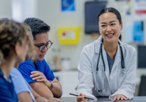 A small group of medical professions meet together to discuss patent cases and plans of care.