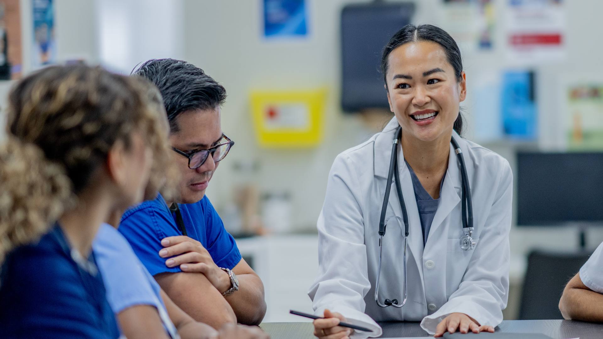 A small group of medical professions meet together to discuss patent cases and plans of care.
