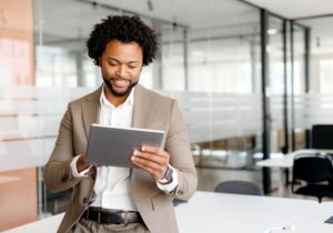 A young confident business man preparing a public value report on his digital tablet.