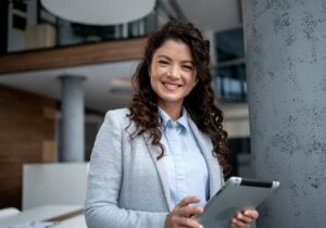 Confident business woman working on a digital transformation project, smiling while holding digital tablet