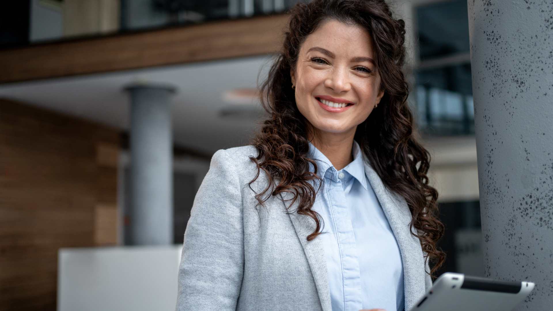 Confident business woman working on a digital transformation project, smiling while holding digital tablet