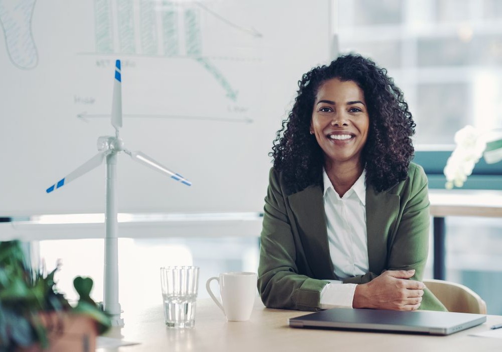 Portrait of a smiling young businesswoman next to a ESG presentation