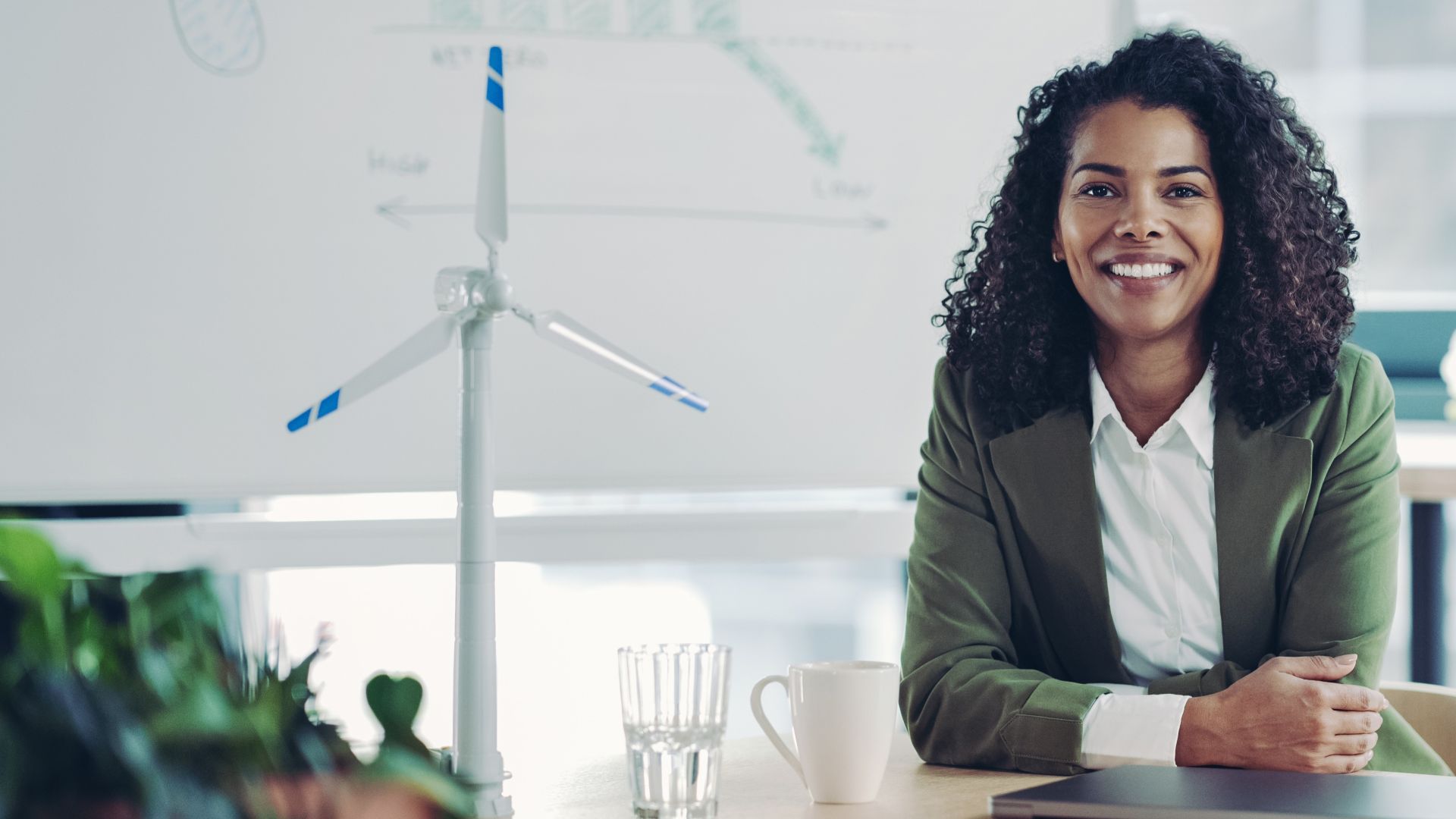Portrait of a smiling young businesswoman next to a ESG presentation